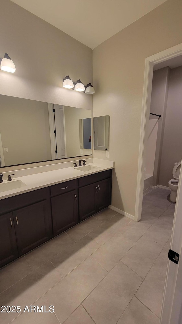 bathroom featuring tile patterned flooring, vanity, and toilet