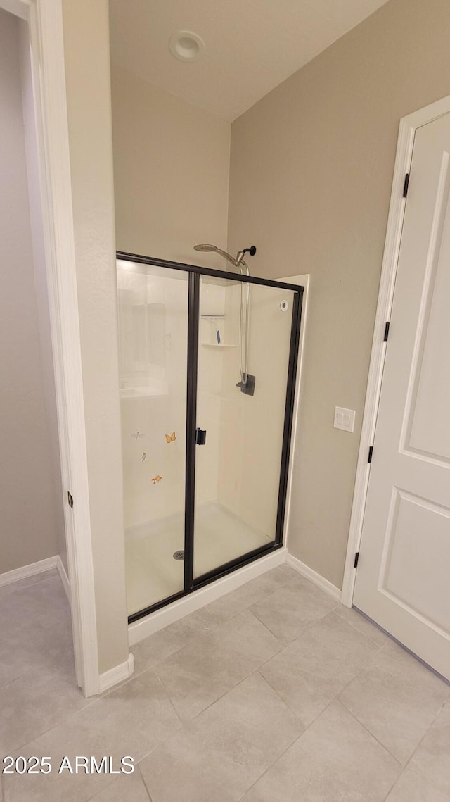 bathroom featuring tile patterned flooring and a shower with shower door