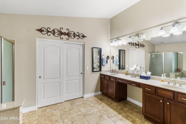 bathroom with lofted ceiling, vanity, tile patterned flooring, and a shower with shower door