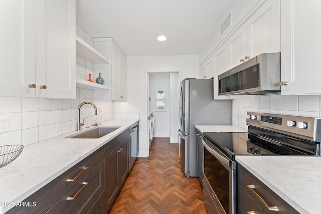 kitchen featuring sink, light stone countertops, white cabinets, and appliances with stainless steel finishes