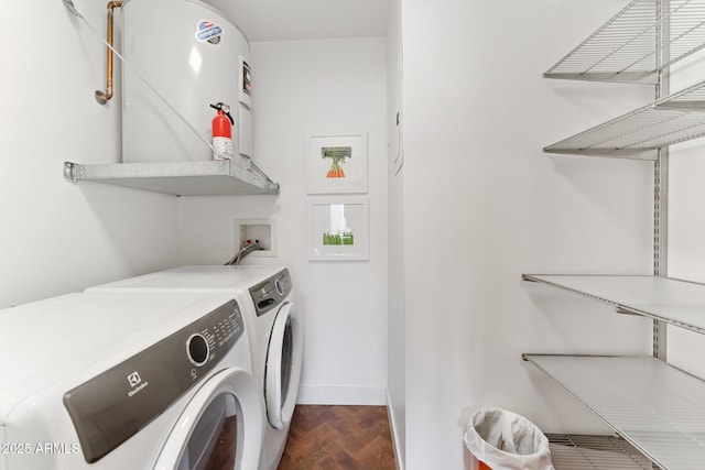 laundry room featuring parquet floors, washing machine and clothes dryer, and electric water heater