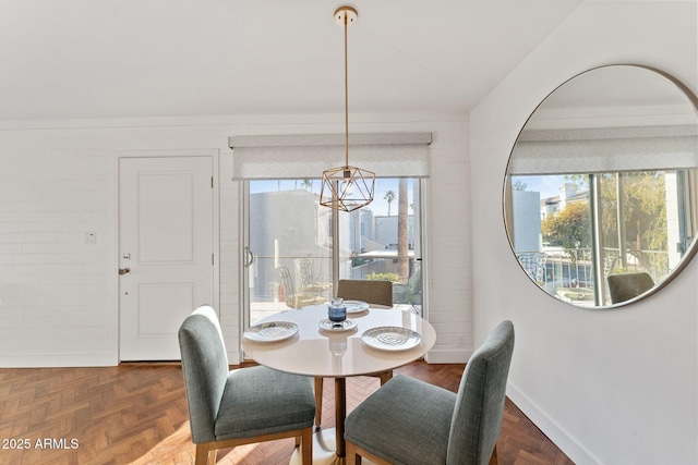 dining space with a chandelier and dark parquet floors