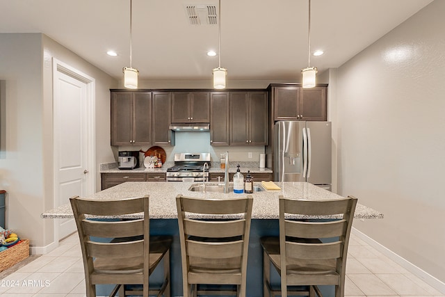 kitchen with dark brown cabinets, an island with sink, and appliances with stainless steel finishes