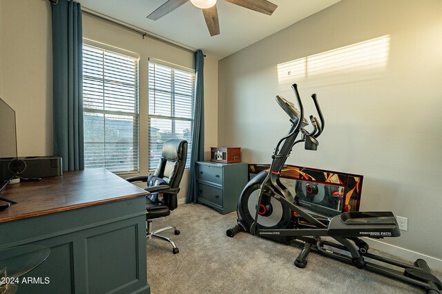 exercise area featuring light carpet and ceiling fan