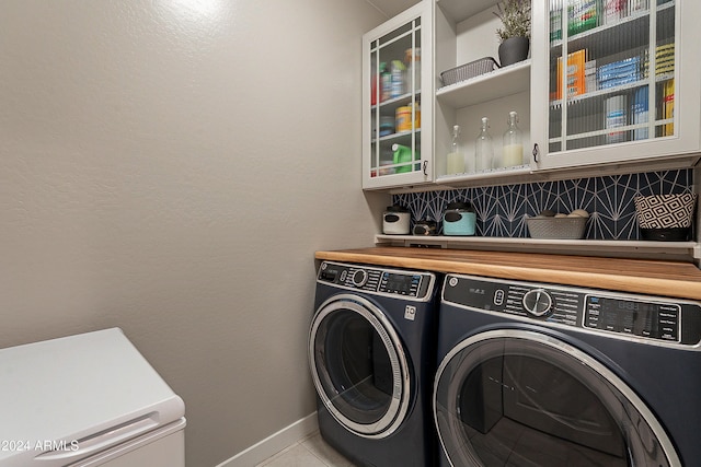 washroom featuring washer and clothes dryer and light tile patterned flooring