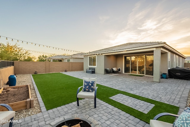 back house at dusk featuring a patio area