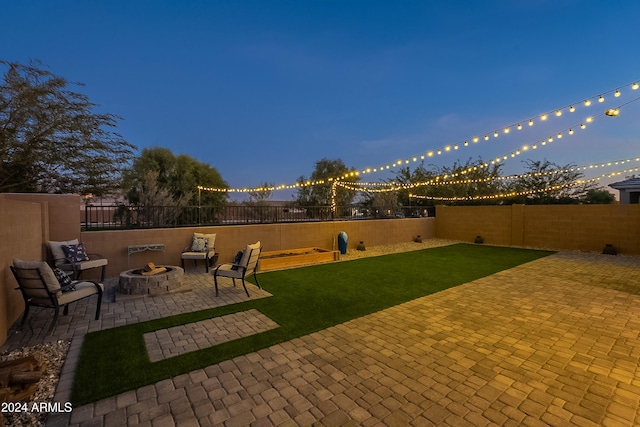 patio terrace at dusk with a yard and an outdoor fire pit