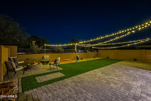 patio at twilight with a yard and an outdoor fire pit