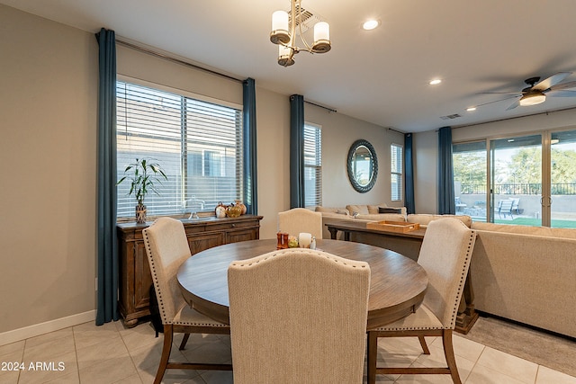 tiled dining area featuring ceiling fan with notable chandelier