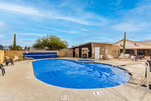 view of swimming pool featuring a community hot tub and a patio