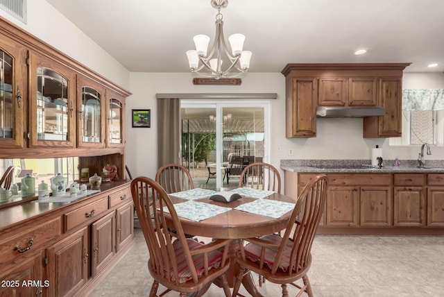 dining area featuring sink and a chandelier