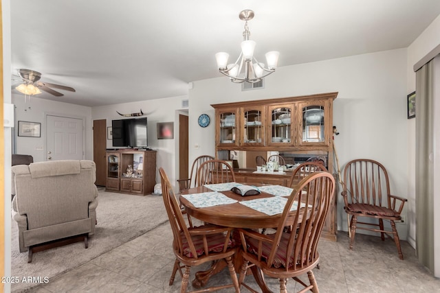 dining space featuring ceiling fan with notable chandelier