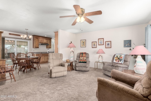 carpeted living room featuring ceiling fan with notable chandelier