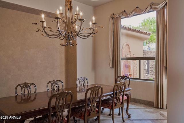dining room with baseboards and a notable chandelier