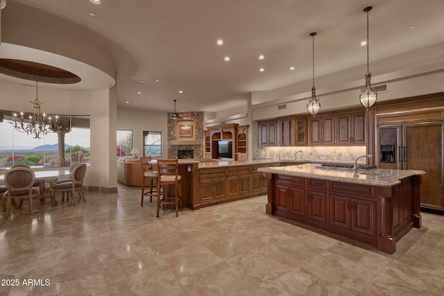 kitchen with a kitchen breakfast bar, open floor plan, a spacious island, tasteful backsplash, and recessed lighting