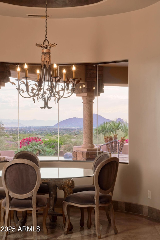dining room featuring baseboards, a wealth of natural light, an inviting chandelier, and a mountain view