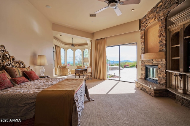 bedroom with a ceiling fan, a stone fireplace, carpet flooring, visible vents, and access to outside