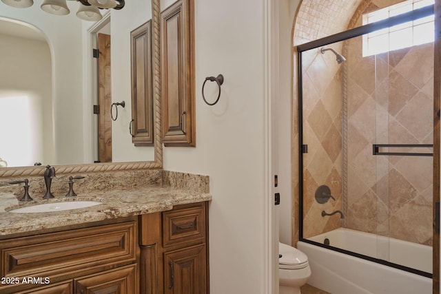 bathroom with toilet, bath / shower combo with glass door, and vanity