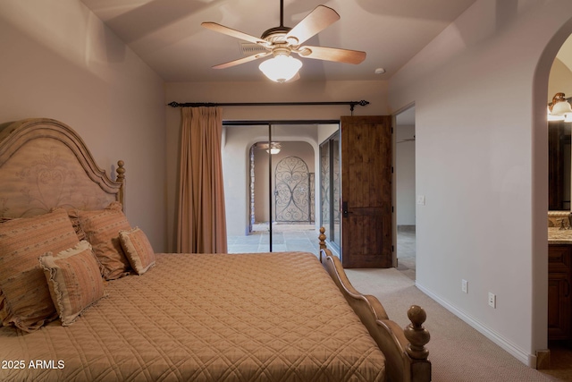 bedroom featuring arched walkways, access to outside, a ceiling fan, and light colored carpet