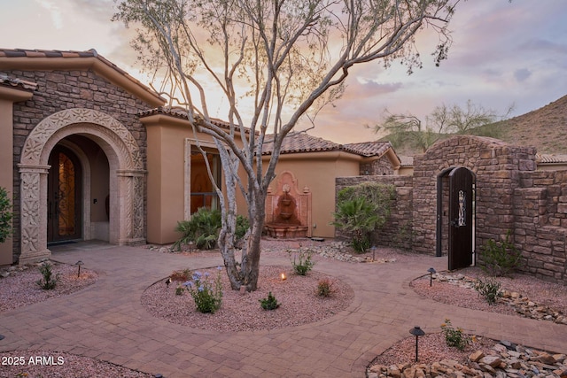 view of front of property featuring stucco siding and a tiled roof