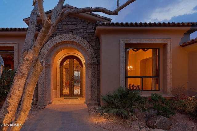entrance to property featuring stucco siding and a tile roof
