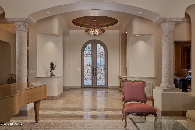 entryway featuring baseboards, ornate columns, french doors, and arched walkways