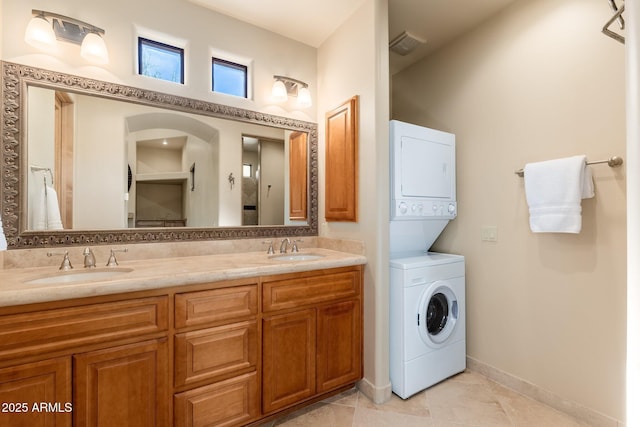 10267 E Cinder Cone Trl, Scottsdale, AZ 85262 - bathroom with stacked washing machine and dryer, double vanity, tile patterned floors, and baseboards