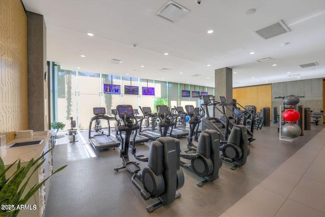 workout area featuring recessed lighting, visible vents, and expansive windows