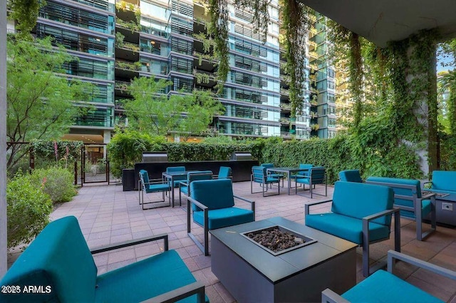 view of patio / terrace with an outdoor living space with a fire pit and outdoor dining area