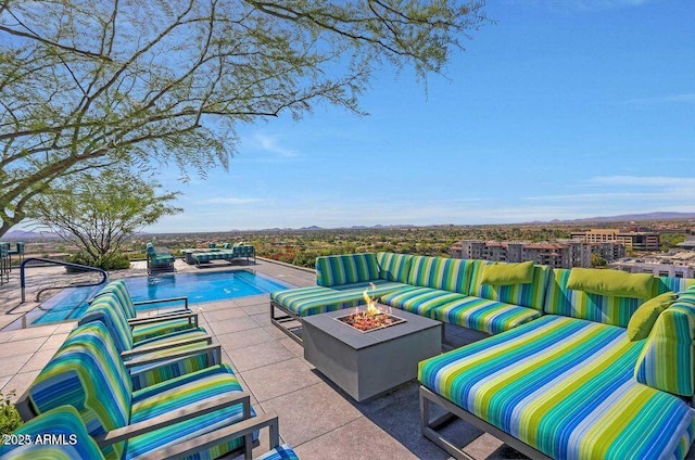 pool featuring a patio and an outdoor living space with a fire pit