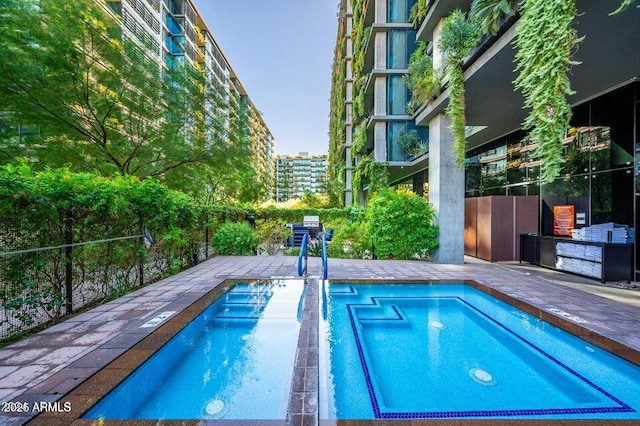 view of swimming pool with a swimming pool and fence