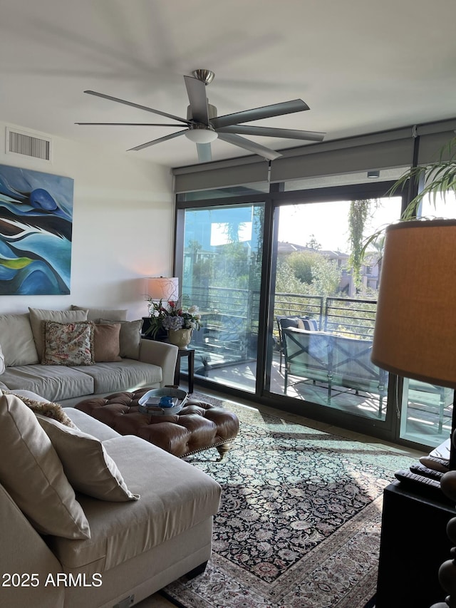 living area featuring visible vents, a healthy amount of sunlight, and ceiling fan