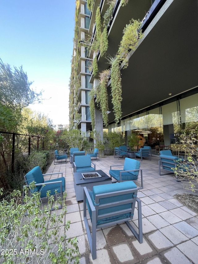 view of patio featuring grilling area, an outdoor living space with a fire pit, and fence