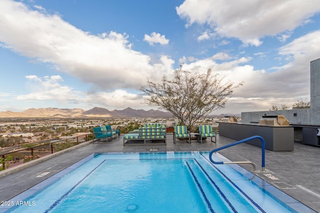 view of pool featuring area for grilling, a patio area, and a mountain view