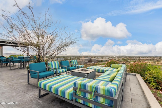 view of patio / terrace with a mountain view and an outdoor living space with a fire pit