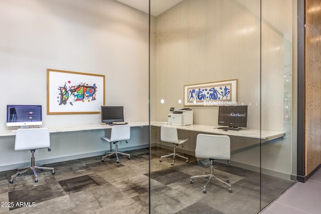 home office with baseboards, a towering ceiling, and built in study area