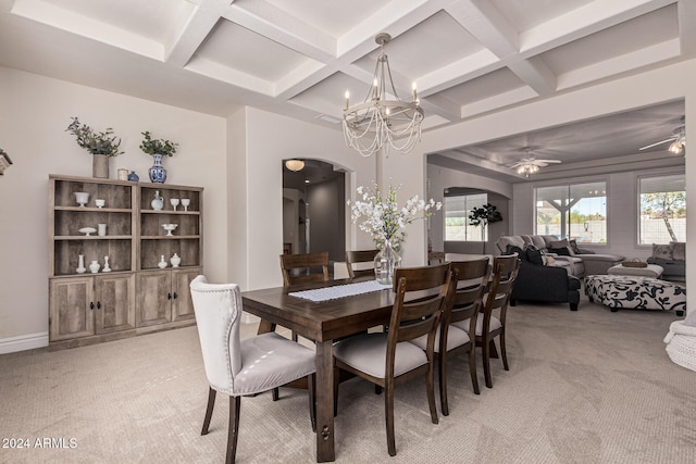 carpeted dining space with ceiling fan with notable chandelier, beam ceiling, and coffered ceiling