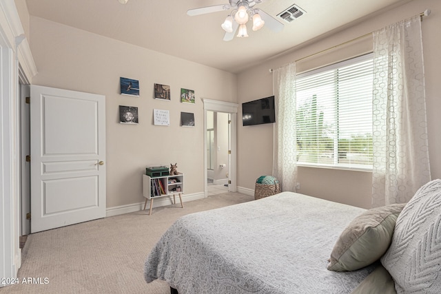 carpeted bedroom with ceiling fan and ensuite bath