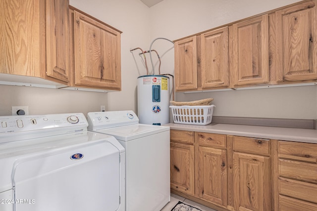 clothes washing area featuring cabinets, water heater, and independent washer and dryer