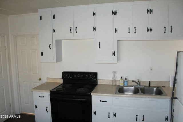 kitchen featuring black range with electric cooktop, stainless steel fridge, sink, and white cabinets