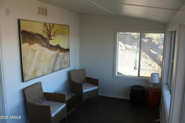 living area featuring lofted ceiling and a healthy amount of sunlight