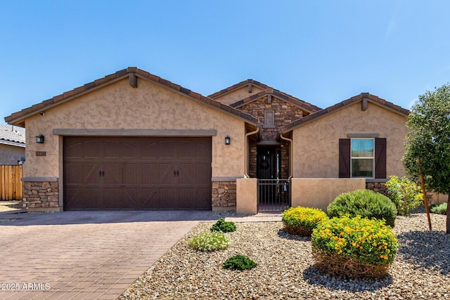 2229 N 139th Dr, Goodyear, AZ 85395 - view of front of house featuring stone siding, a garage, stucco siding, decorative driveway, and fence private yard