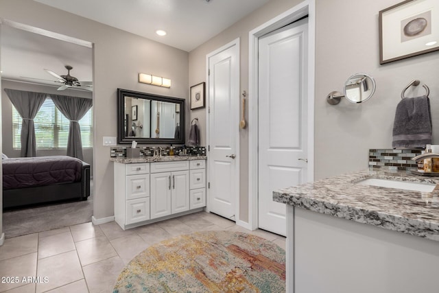 2229 N 139th Dr, Goodyear, AZ 85395 - ensuite bathroom featuring decorative backsplash, connected bathroom, tile patterned floors, two vanities, and a ceiling fan