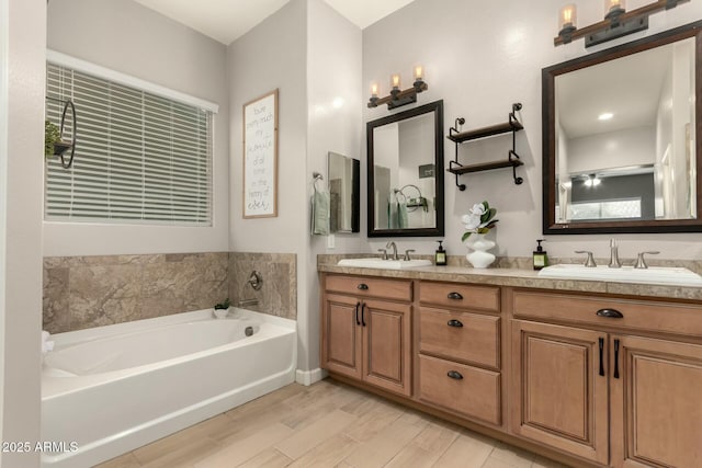 bathroom with hardwood / wood-style flooring, vanity, and a bath