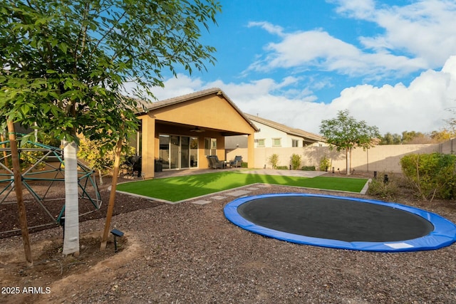 back of property featuring a patio area and a trampoline