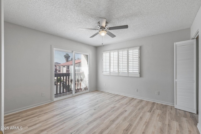 unfurnished bedroom with baseboards, wood finished floors, a textured ceiling, and access to exterior