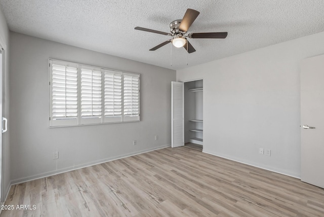 unfurnished bedroom featuring baseboards, a textured ceiling, wood finished floors, and a ceiling fan