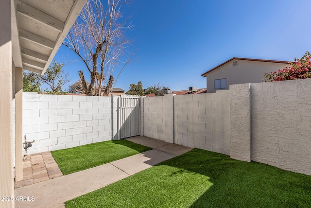 view of yard featuring a fenced backyard and a gate