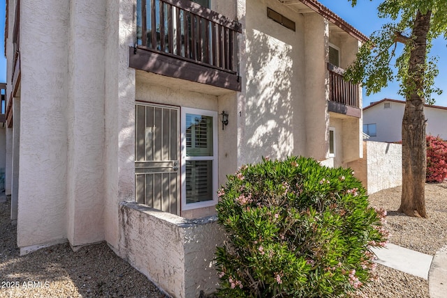 exterior space with stucco siding and a balcony