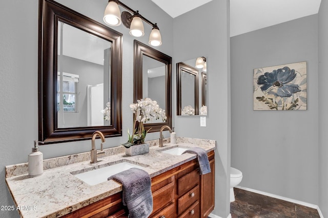 1314 S Bridgegate Dr, Gilbert, AZ 85296 - bathroom featuring double vanity, toilet, baseboards, and stone finish flooring